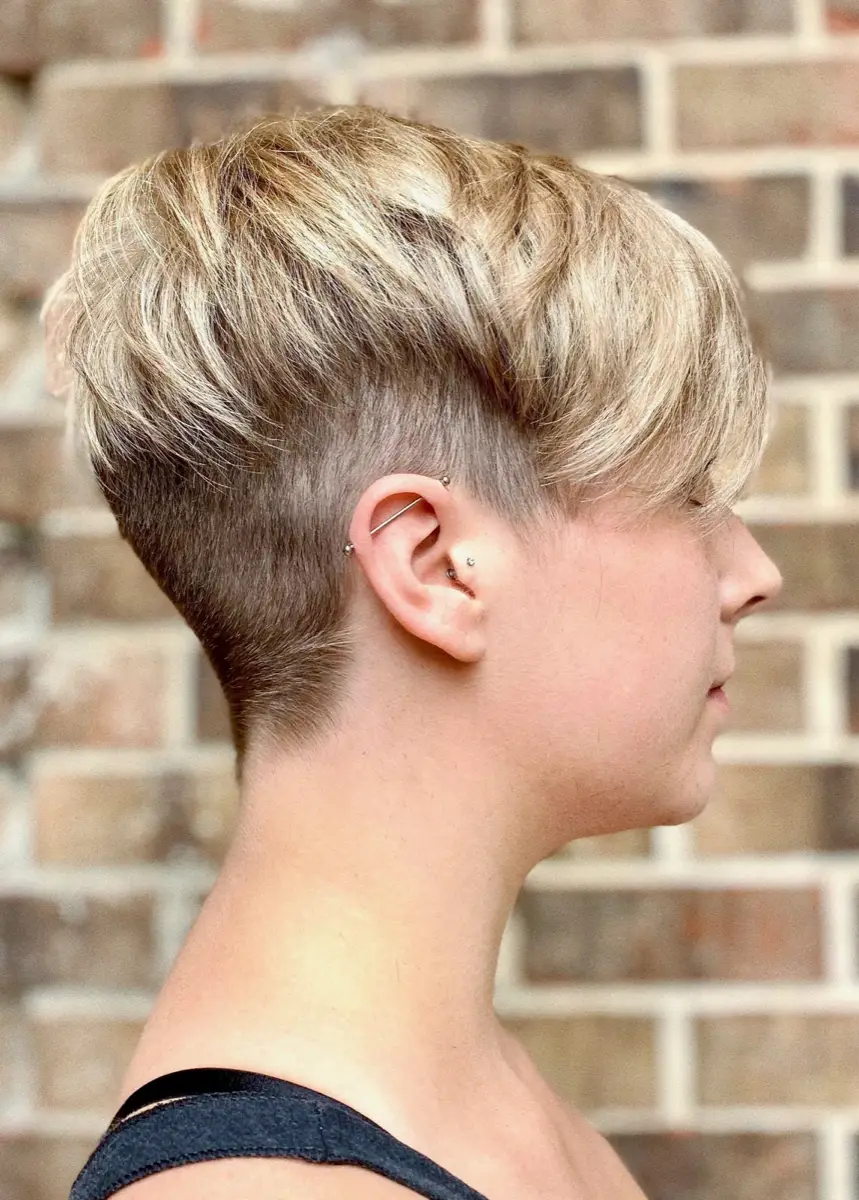 Blonde undercut pixie cut with a soft fringe and tapered nape, side profile