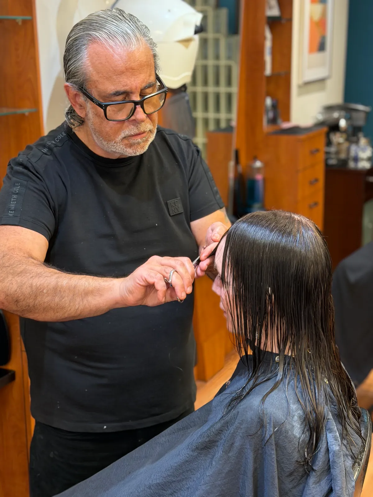 Michele Anzivino cutting a guest's hair at Ciao Bella Salon