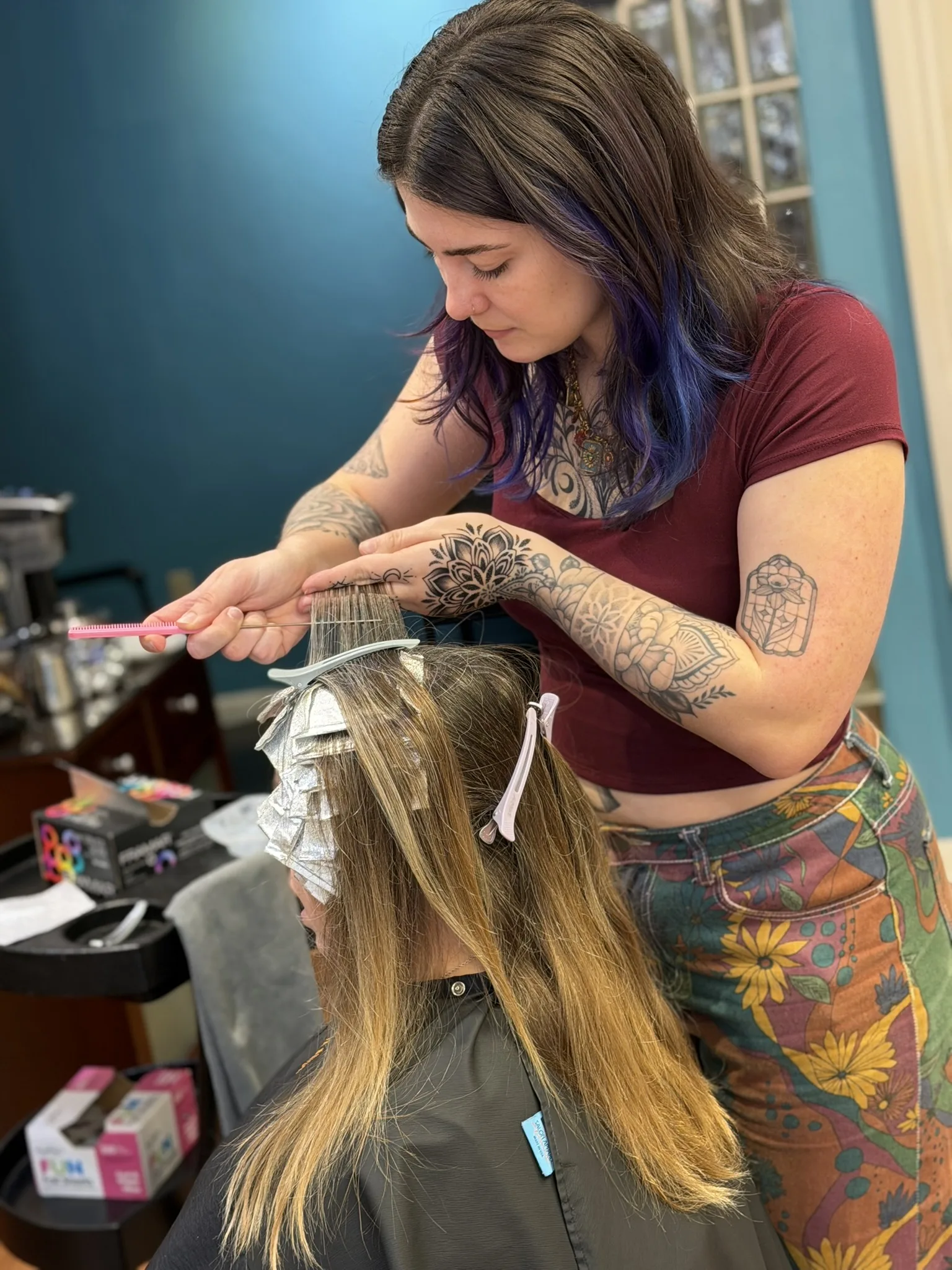 Stylist hand-painting and foiling a client's balayage in the salon