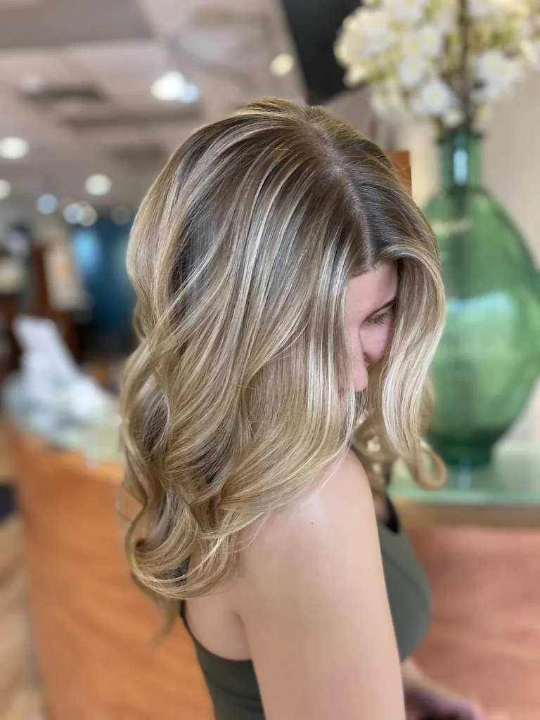 Dimensional blonde balayage with soft waves, side profile
