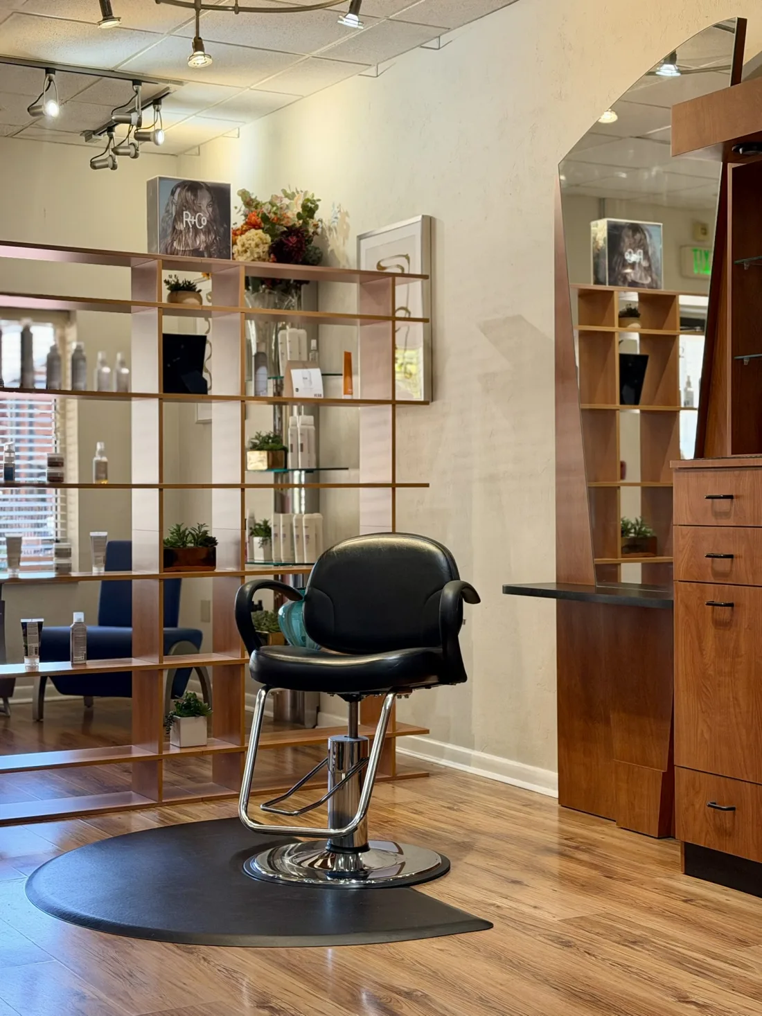 An open styling station at Ciao Bella Salon, chair turned toward the mirror, ready for a new stylist
