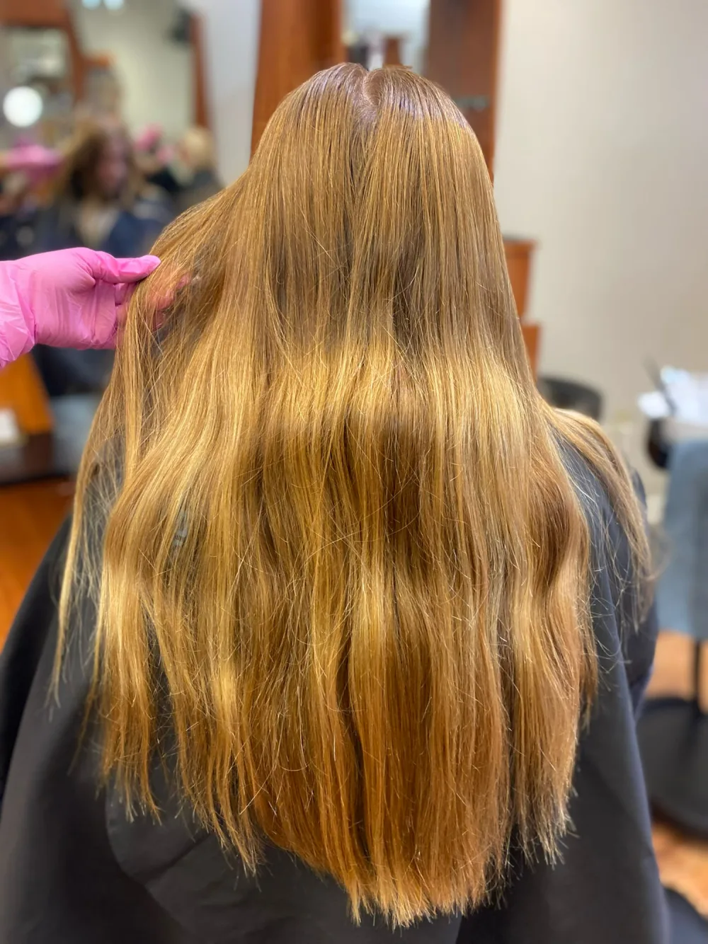Before color correction: uneven brassy golden-orange color with dark roots and warm bands