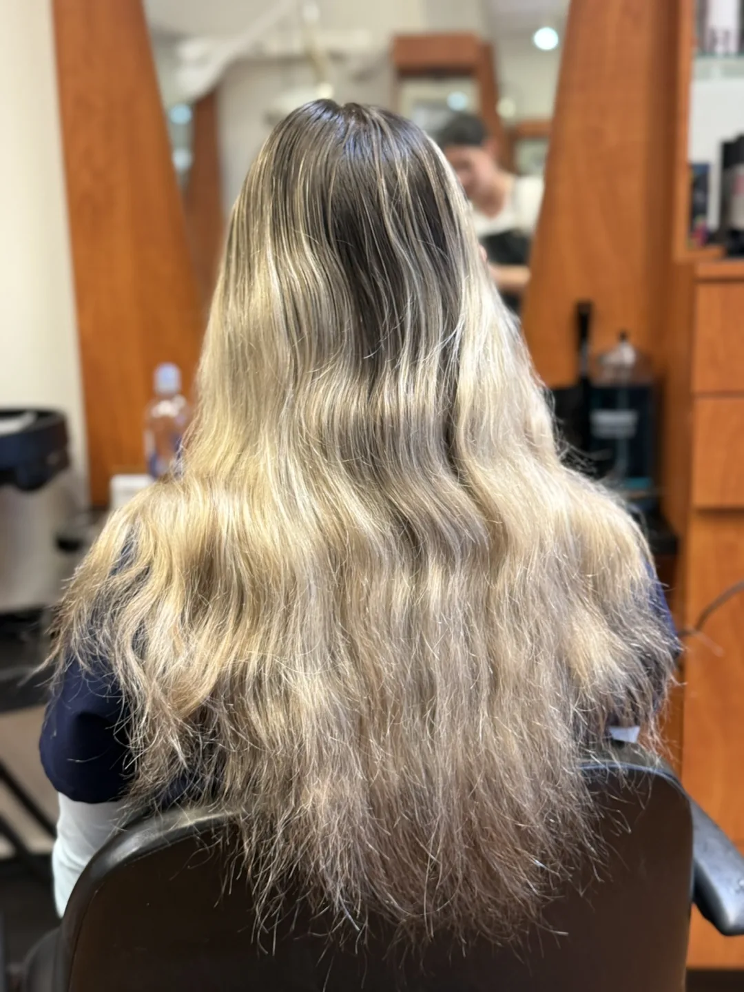 Before color correction: brassy, over-processed blonde with uneven bands and dry ends