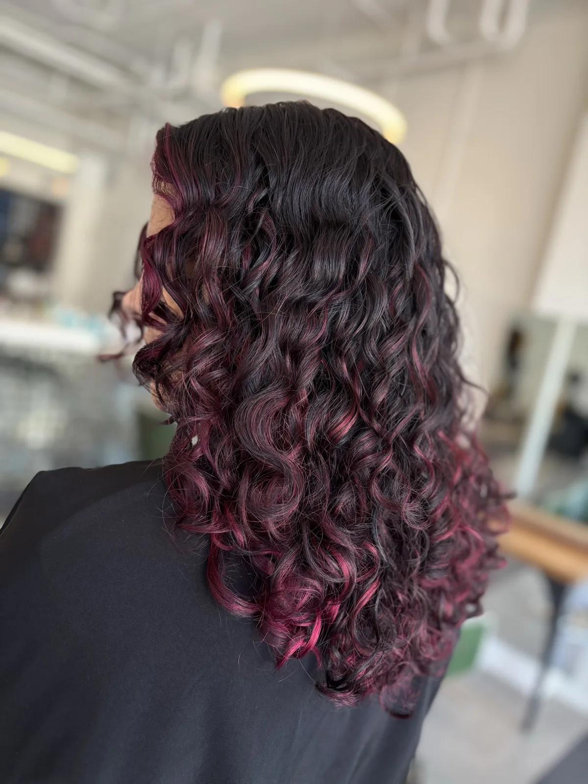 Soft dark curls with burgundy ribbons of color, shaped curl by curl at Ciao Bella