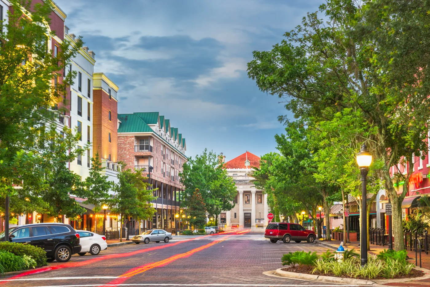 Tree-lined Main Street in downtown Gainesville at dusk, steps from Ciao Bella Salon