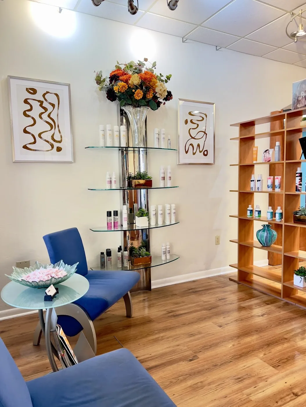 The waiting area at Ciao Bella Salon in Gainesville, with blue chairs, a magazine table, and shelves of hair products